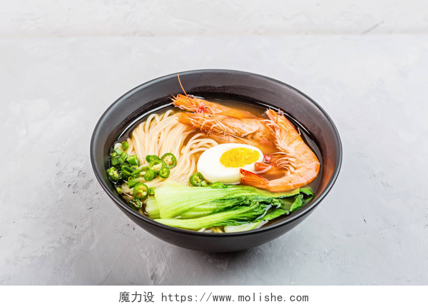灰色背景上的一碗海鲜面亚洲面汤、虾仁拉面、蔬菜和鸡蛋在灰色混凝土背景的黑色碗中。 平躺在地上,俯瞰,模拟,头顶. 健康食品概念